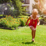 Menina brincando descalça em um gramado de grama bermuda.