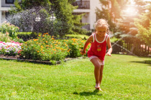 Menina brincando descalça em um gramado de grama bermuda.