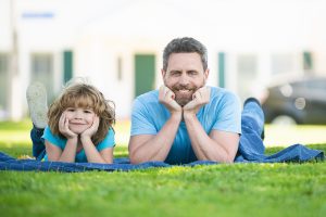 Pai e filho deitados no gramado de grama São Carlos