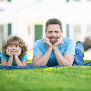 Pai e filho deitados no gramado de grama São Carlos